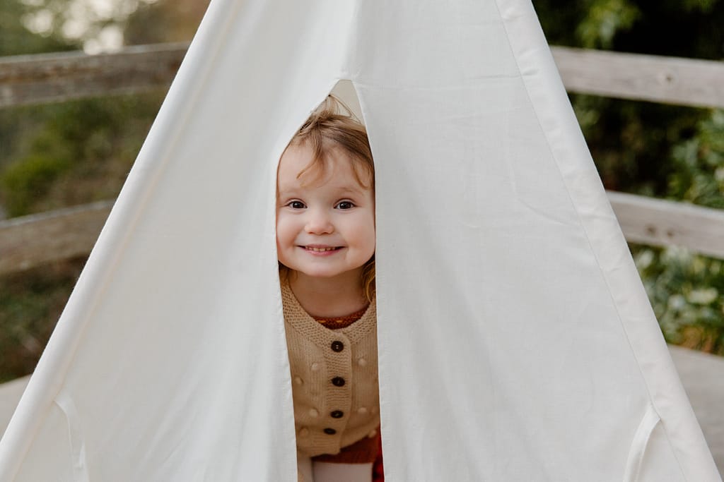 cute kid smiling through tent